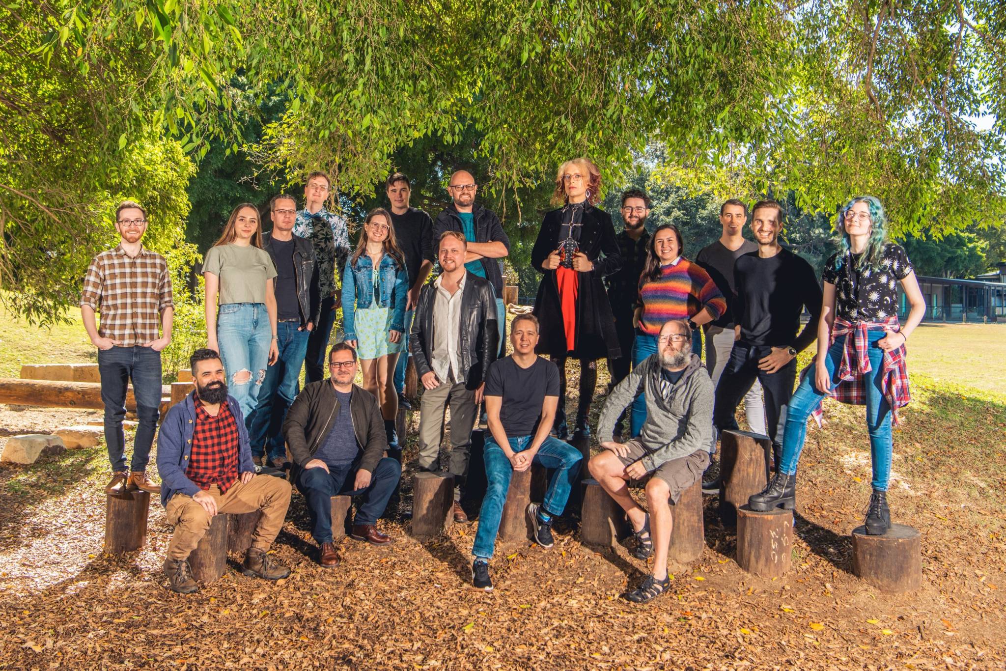 A photo of the 5 Lives Studios team who are a diverse group of people standing outside and smiling