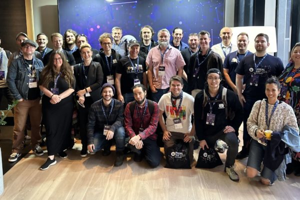 A group photo of the Gameloft Brisbane team. they are smiling together and wearing lanyards at Unreal Fest